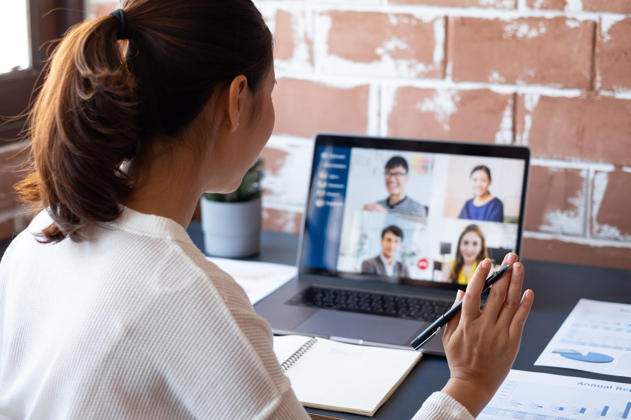 Young Asian businesswoman work at home and virtual video conference meeting with colleagues business people, online working, video call due to social distancing at home office