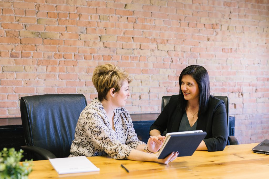 Two employees going over carrier feeds during open enrollment