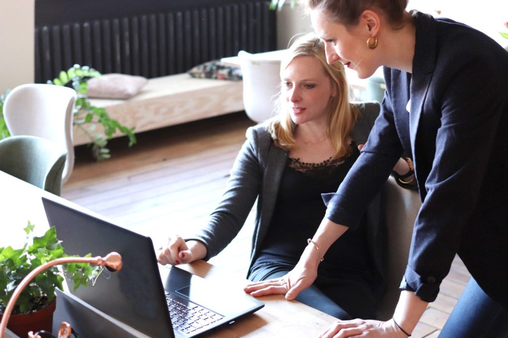 two businesswomen going over hcm software